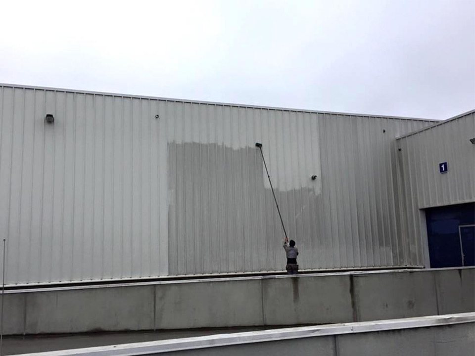 Gevelreiniging met een lans aan een bedrijfsgebouw