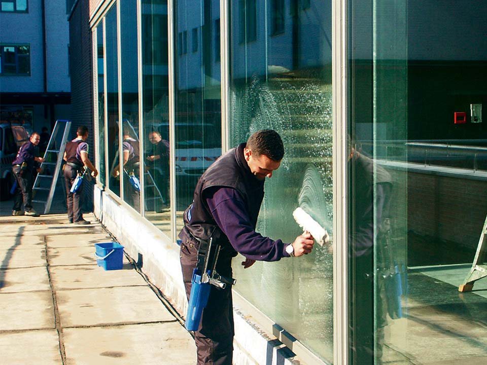 Ruitenwassers aan een grote glazen gevel
